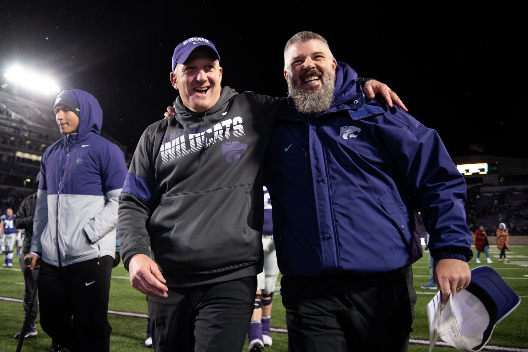 K-State head coach Chris Klieman and K-State defensive coordinator Scottie Hazelton walk off the field embracing one another